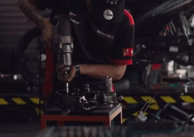 Mecánico usando herramienta eléctrica en el freno de una motocicleta
