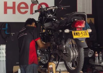 Mecánico trabajando en una motocicleta Hero negra en el taller